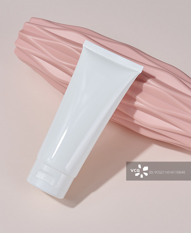 米色背景上的白色塑料化妆品软管包装图片素材