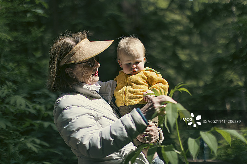 祖母抱着小宝宝在雨林中徒步旅行图片素材