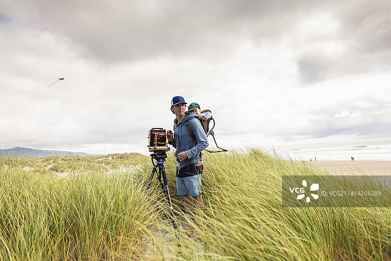 父亲扛着孩子站在老式4x5相机旁图片素材