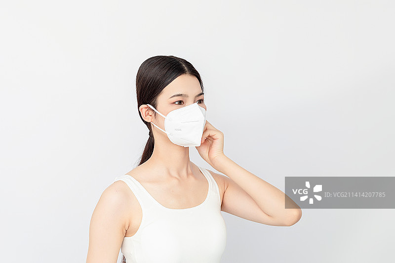 白色背景一名戴KN95口罩的亚洲年轻女性图片素材