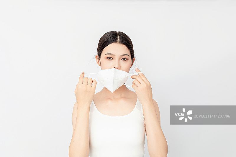白色背景一名戴KN95口罩的亚洲年轻女性图片素材