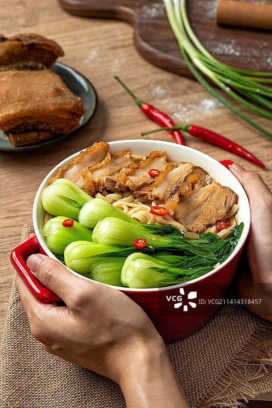 45度视角竖构图的中式过油肉汤面和双手图片素材