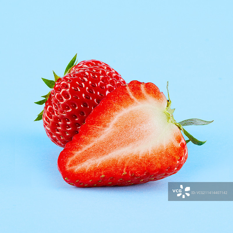 新鲜的草莓孤立在蓝色背景上图片素材