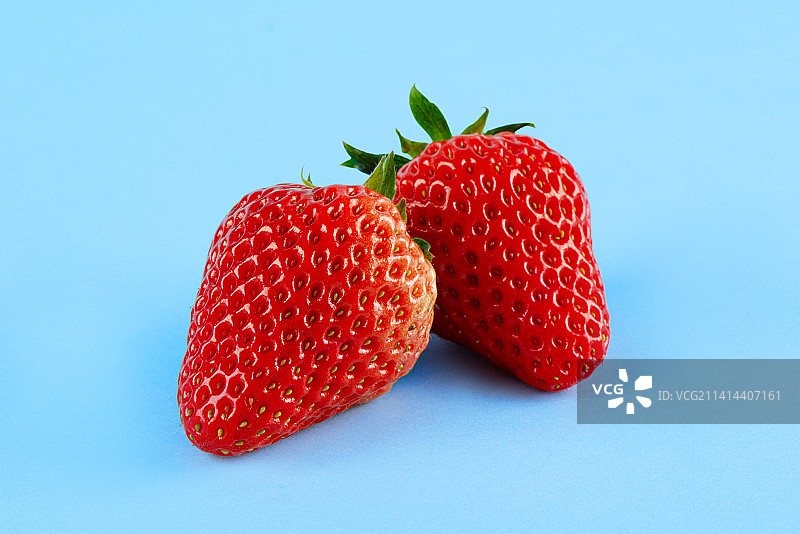新鲜的草莓孤立在蓝色背景上图片素材