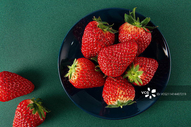 新鲜的草莓孤立在绿色背景上图片素材