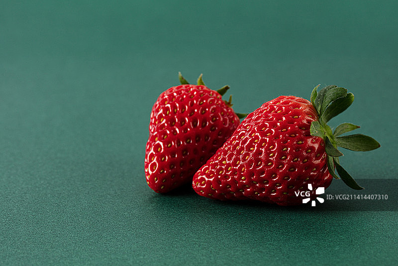 新鲜的草莓孤立在绿色背景上图片素材
