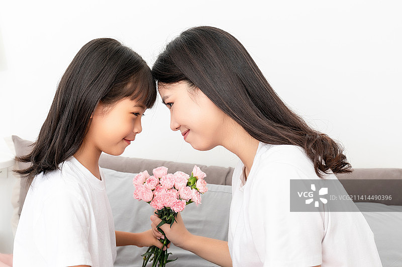 母亲节概念中国小女孩给妈妈送花图片素材