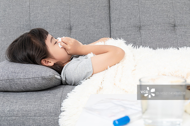 客厅沙发上一个感冒生病的小女孩图片素材