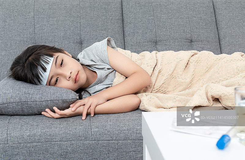 客厅沙发上一个感冒生病的小女孩图片素材
