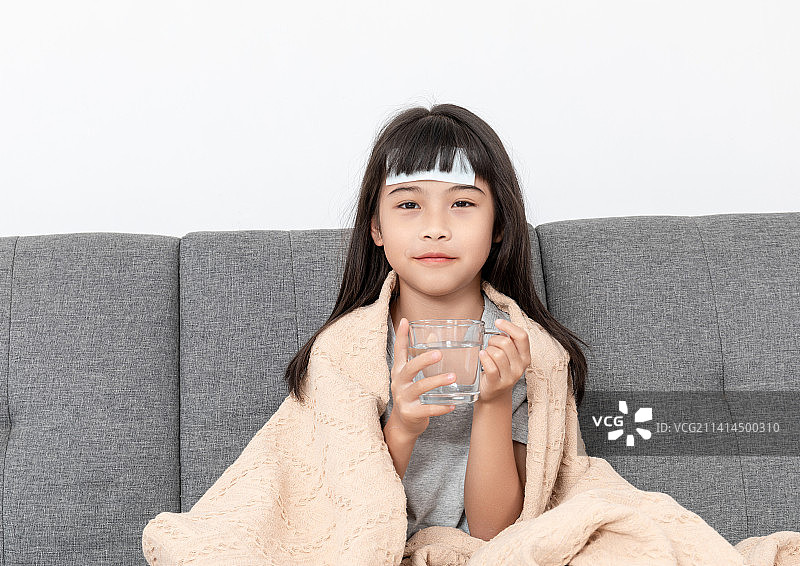 客厅沙发上一个感冒生病的小女孩图片素材