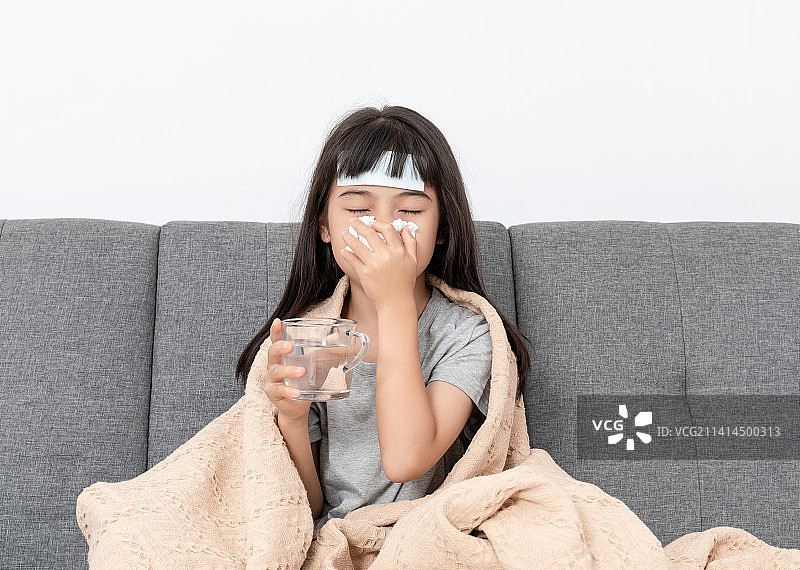 客厅沙发上一个感冒生病的小女孩图片素材