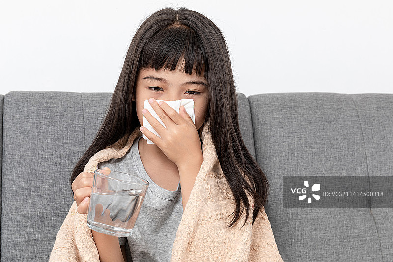 客厅沙发上一个感冒生病的小女孩图片素材