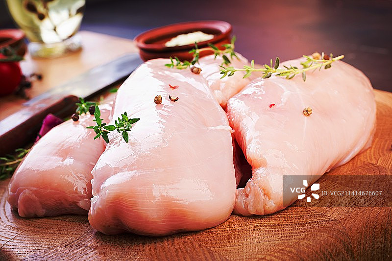 木制砧板上的生鸡胸肉与香草图片素材