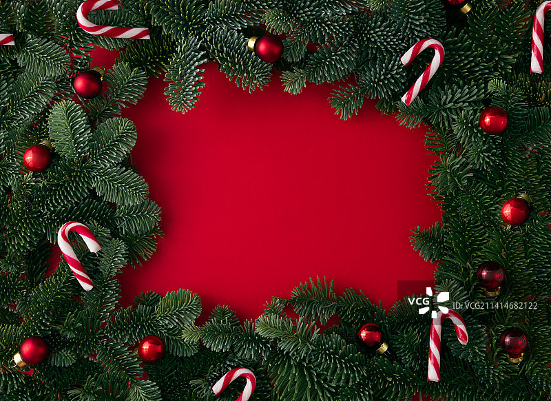 红色背景上带有节日装饰的圣诞树枝框架图片素材