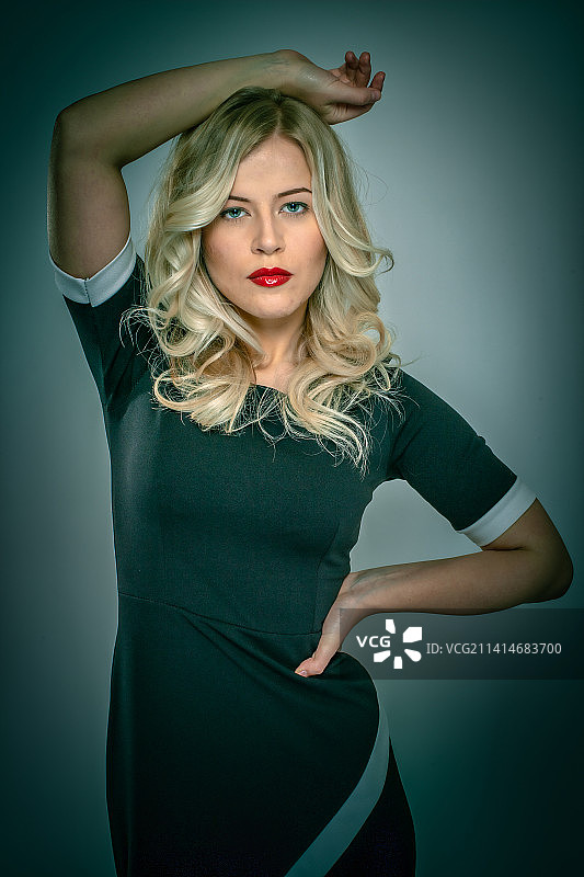 年轻女子站在灰色背景前，意大利拉斯佩齐亚图片素材