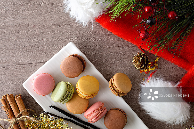 西班牙餐桌上堆叠的什锦马卡龙与帽子图片素材