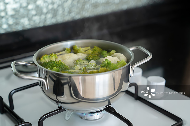 燃气灶上用银色金属锅水煮新鲜绿色西兰花，土耳其图片素材