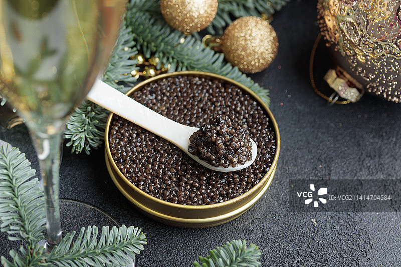 带有圣诞装饰的珍珠贝壳勺中的黑色鱼子酱，芬兰图片素材
