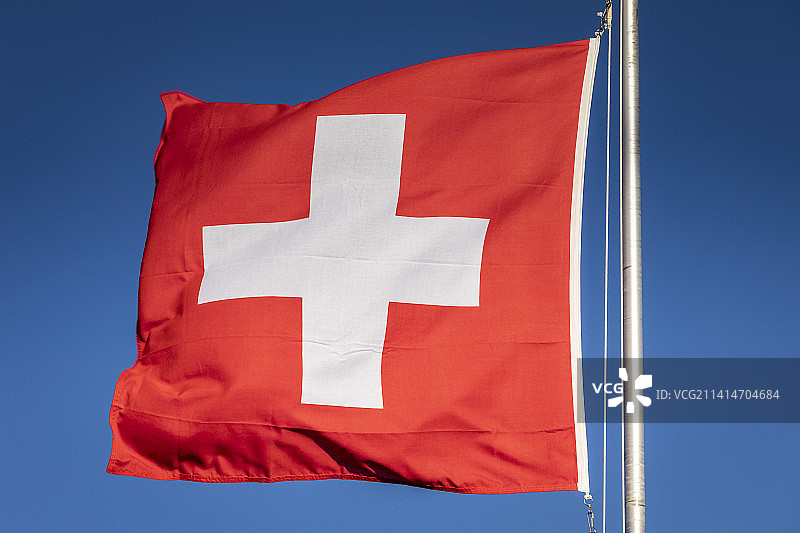 蓝天背景下的瑞士国旗和瑞士阿尔卑斯山图片素材