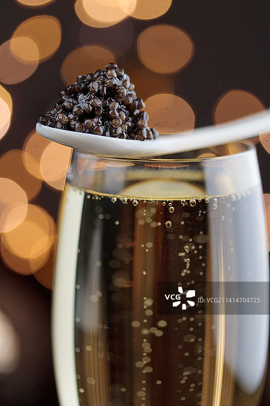 珍珠母贝勺中的黑色鱼子酱和香槟图片素材