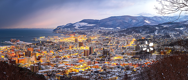 日本北海道小樽旭展望台，冬季大雪城市夜景与海岸图片素材