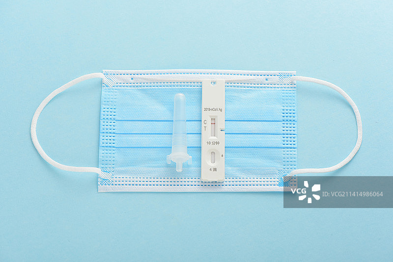 蓝色背景上的核酸检测抗原检测试剂和口罩图片素材