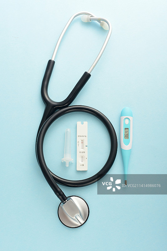 蓝色背景上的核酸检测抗原检测试剂和听诊器图片素材