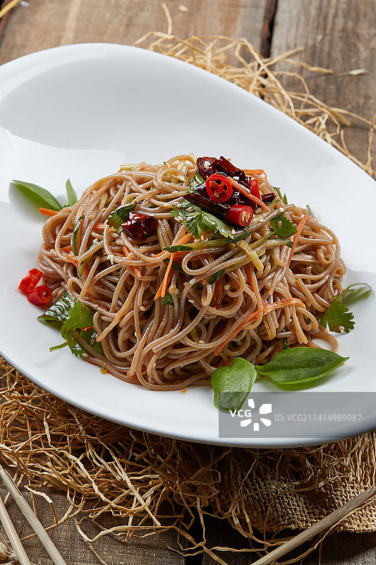 白色瓷盘装的的香辣荞麦凉面图片素材