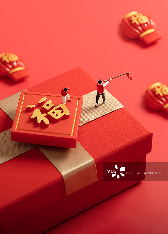 微缩创意春节在红色礼物盒上放鞭炮的父子图片素材