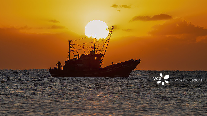 迎着日出出航图片素材