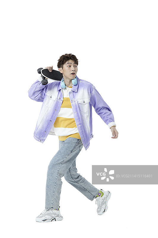 白背景下玩滑板的年轻男性图片素材