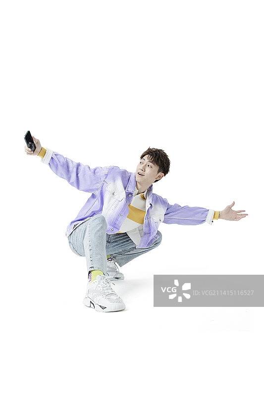 跳着街舞耍着手机的年轻人图片素材