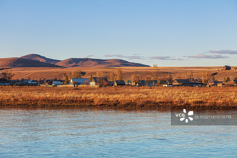 秋天黄昏日落时分中俄边境室韦口岸，隔界额尔古纳河眺望对岸的俄罗斯小镇奥洛契，村里的木结构民居清晰可见图片素材