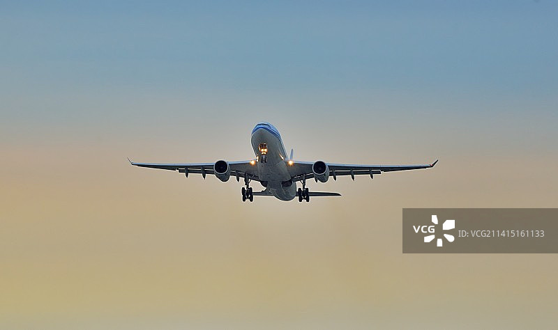 一架飞机飞过日出时的天空特写图片素材