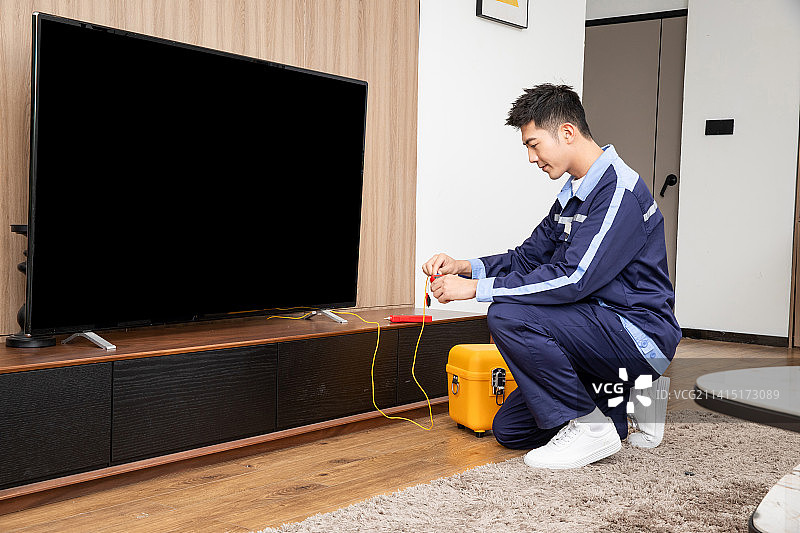 在客厅调试电视网络的工程师图片素材