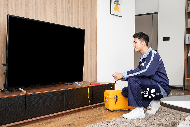 在客厅调试电视网络的工程师图片素材