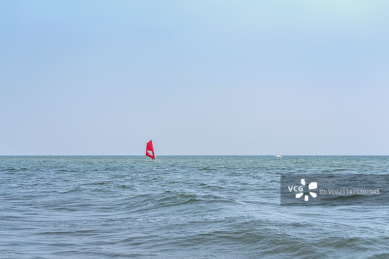 乘风破浪.大海中漂浮的一叶帆船与海天一色相连的水面图片素材