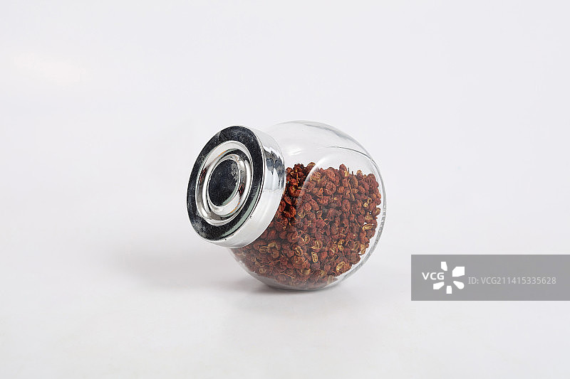 透明玻璃瓶里的花椒粒在白色背景上图片素材