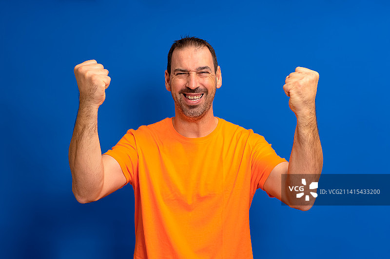 身穿橙色T恤的快乐男子图片素材