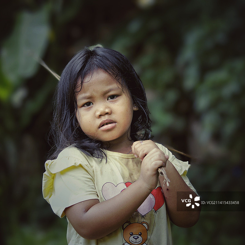 拿着树叶的可爱女孩肖像图片素材