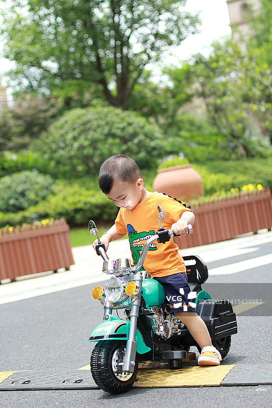 骑着摩托车的中国小男孩图片素材