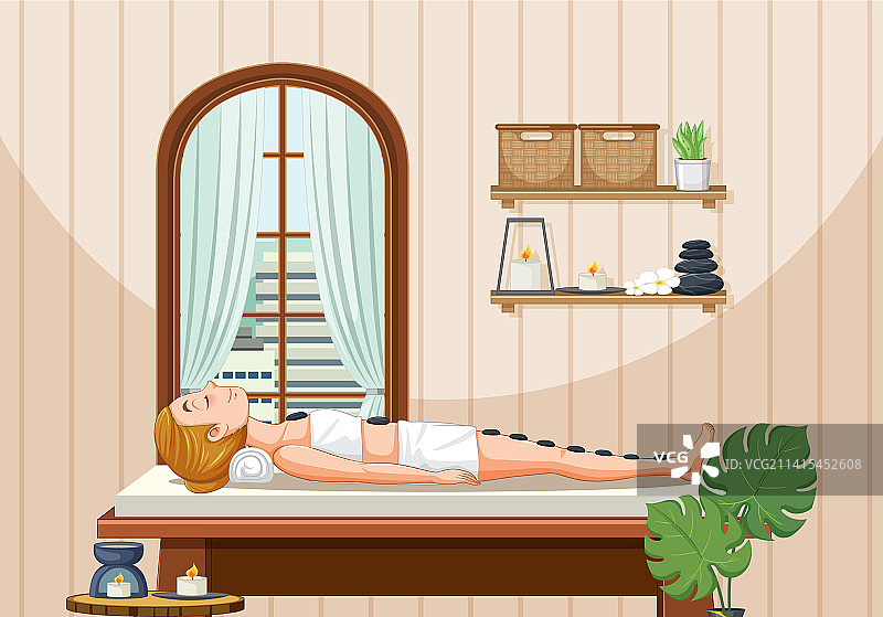 女人在水疗馆接受热石按摩图片素材