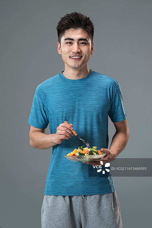 吃蔬菜沙拉的青年男人图片素材