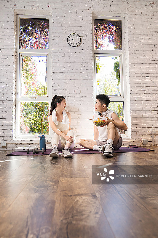 健身完的青年夫妇坐在地上休息图片素材