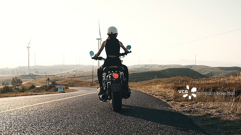 郊外骑摩托车的年轻女人背影图片素材