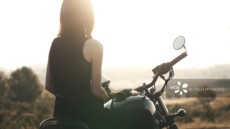 郊外骑着摩托车的性感年轻女人图片素材