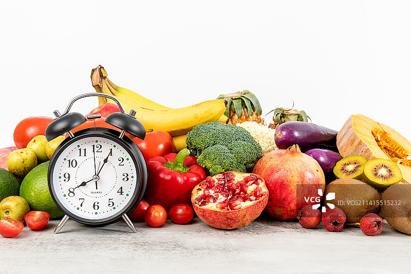 丰富多种的新鲜蔬菜水果和一个闹钟图片素材