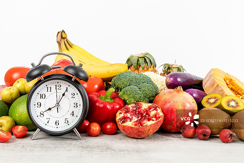 丰富多种的新鲜蔬菜水果和一个闹钟图片素材