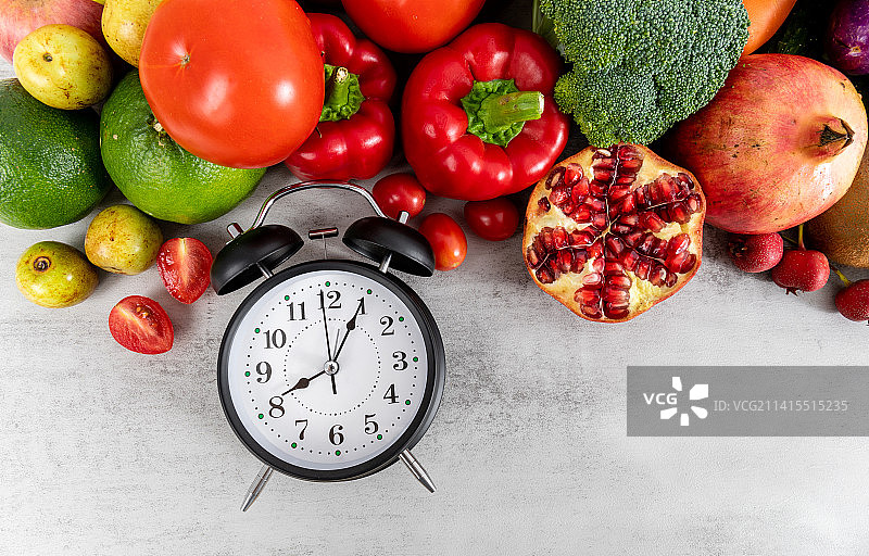丰富多种的新鲜蔬菜水果和一个闹钟图片素材