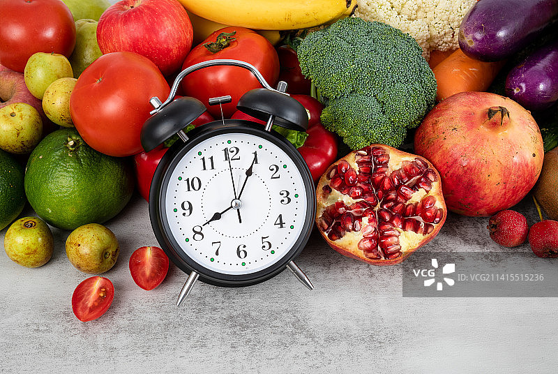 丰富多种的新鲜蔬菜水果和一个闹钟图片素材